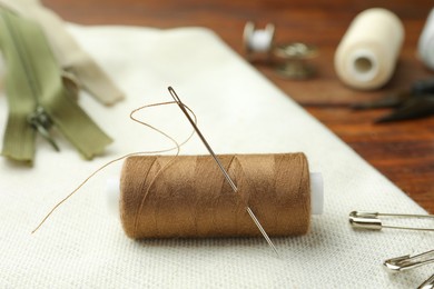 Photo of Thread and other sewing supplies on wooden table