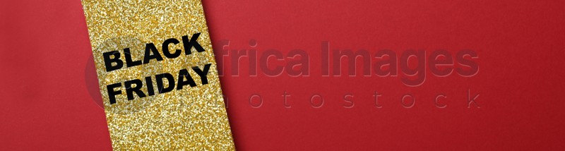 Golden tag with words Black Friday on red background, top view with space for text. Banner design