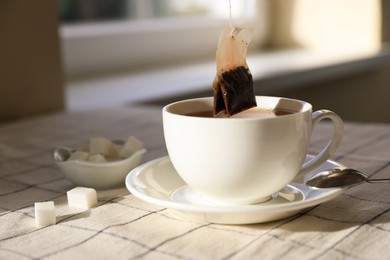 Photo of Taking tea bag out of cup on table indoors, closeup