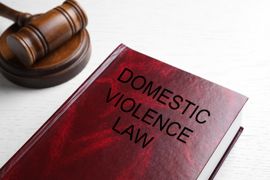 Domestic violence law and gavel on white wooden table, closeup