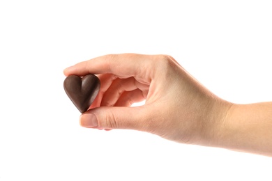 Woman holding heart shaped chocolate candy on white background, closeup