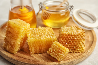 Photo of Fresh delicious honeycombs on wooden board, closeup