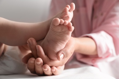 Mother holding her baby, closeup on feet