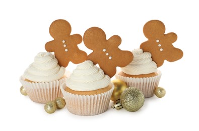 Tasty cupcakes with gingerbread men and Christmas baubles on white background