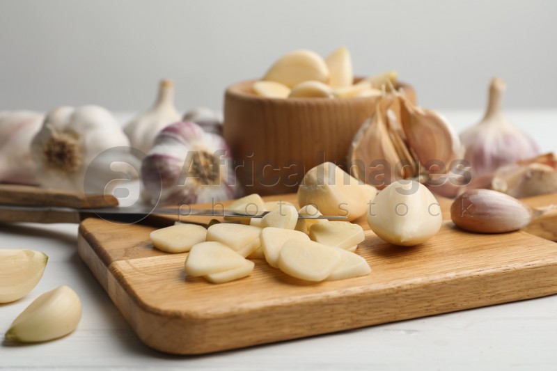 Fresh chopped garlic on wooden board, closeup. Organic product
