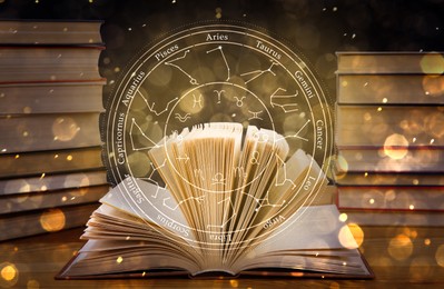 Open book on wooden table and illustration of zodiac wheel with astrological signs