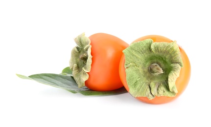 Delicious persimmons and green leaf isolated on white