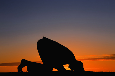 Silhouette of Muslim man praying at sunset. Holy month of Ramadan