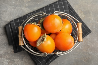 Delicious fresh persimmons on grey table, flat lay