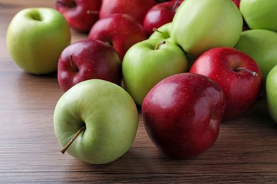 Fresh ripe red and green apples on wooden table, closeup