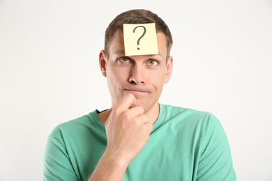 Thoughtful man with question mark on white background