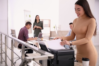 Employee using new modern printer in office