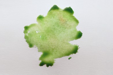 Photo of Green ink blot on white canvas, top view