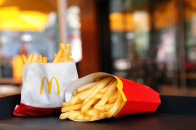 MYKOLAIV, UKRAINE - AUGUST 11, 2021: Big and small portions of McDonald's French fries on tray in cafe