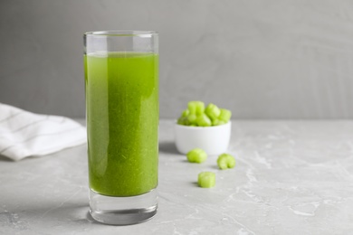 Photo of Glass of fresh celery juice on grey table, closeup. Space for text