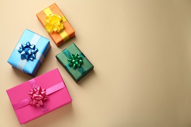 Many colorful gift boxes on beige background, flat lay. Space for text
