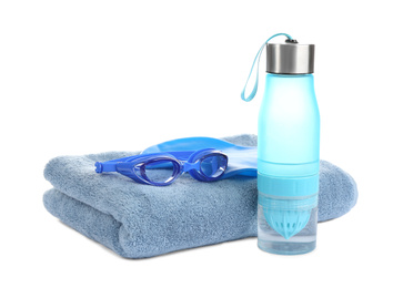Swimming cap, goggles, water bottle and towel isolated on white
