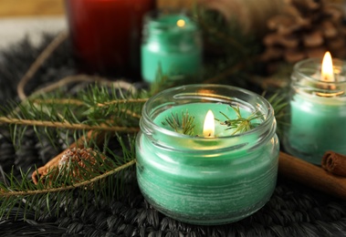 Burning scented conifer candles and Christmas decor on table