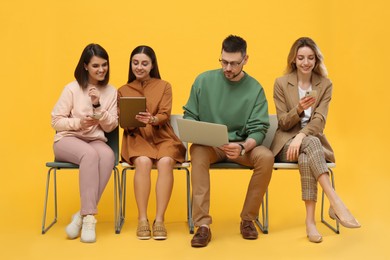 People waiting for job interview on yellow background