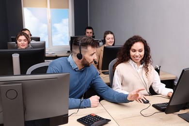 Call center operators with headset working in modern office