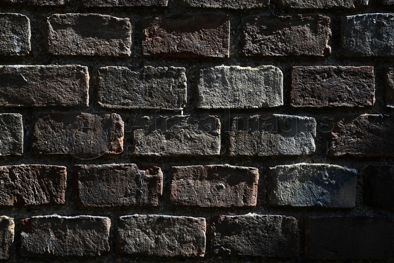 Texture of dark brick wall as background, closeup view