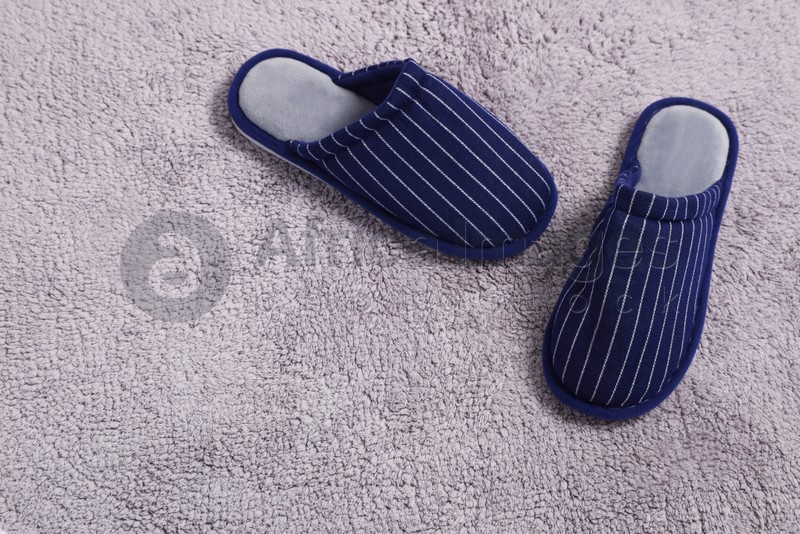 Photo of Pair of stylish slippers on light grey carpet, top view. Space for text