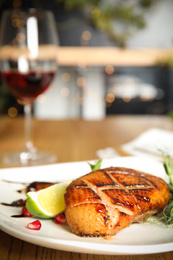 Photo of Delicious grilled duck breast served on wooden table indoors, closeup. Space for text