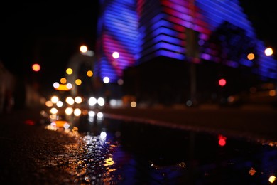 Photo of View of cityscape with bokeh effect, focus on asphalt. Night life