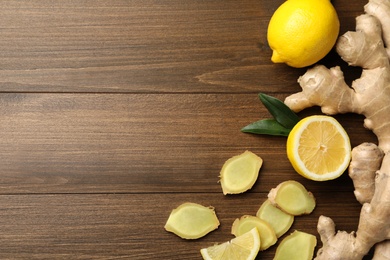 Fresh lemons and ginger on wooden table, flat lay. Space for text