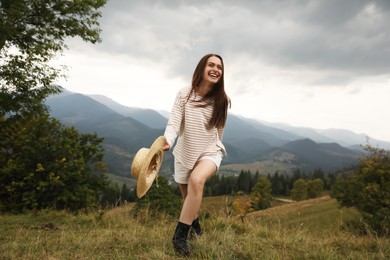 Young woman with stylish hat enjoying her time in mountains