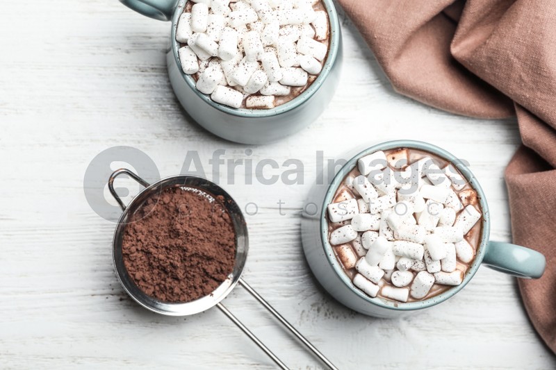 Flat lay composition with delicious cocoa drink on white wooden table