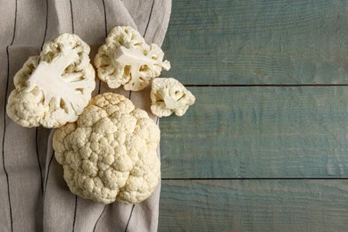 Photo of Fresh raw cauliflower on light blue wooden table, flat lay. Space for text