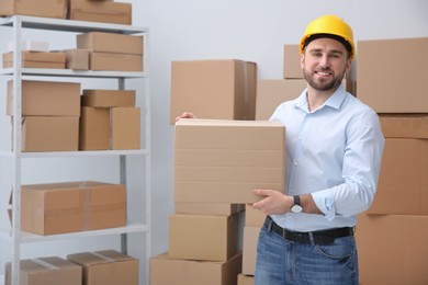 Young man with cardboard box at warehouse