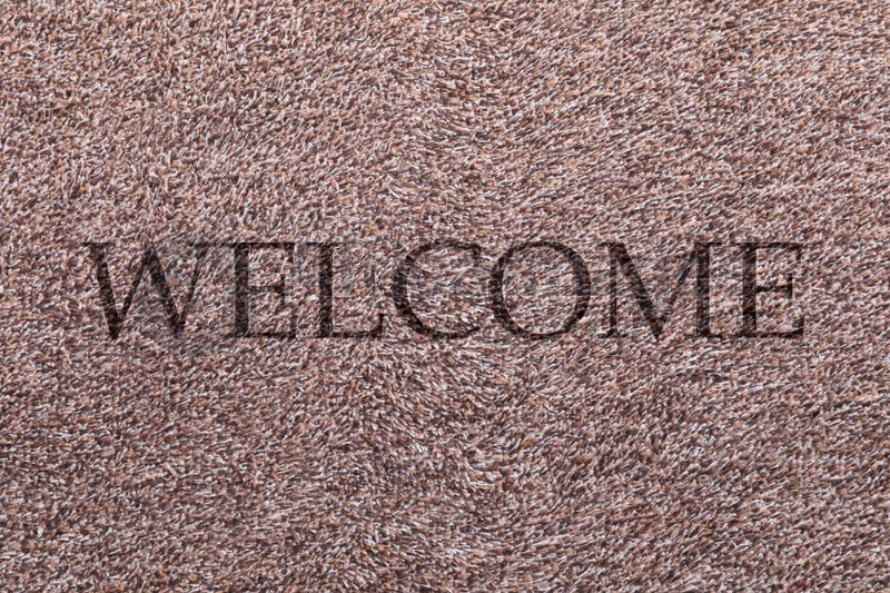 Door mat with word WELCOME as background, top view