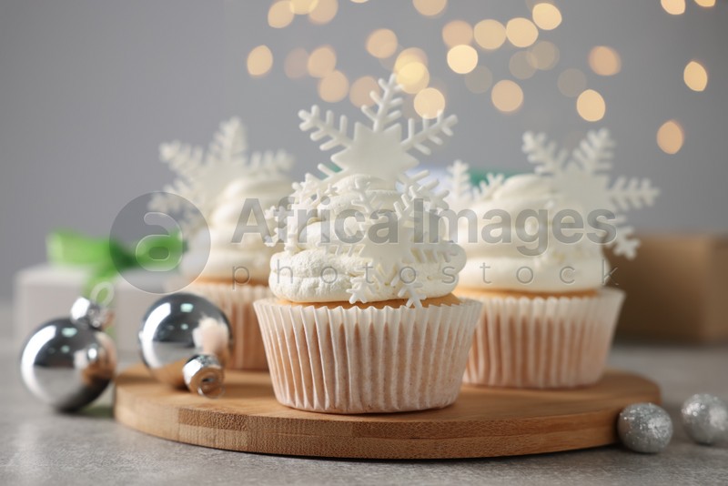 Photo of Tasty Christmas cupcakes with snowflakes on grey table
