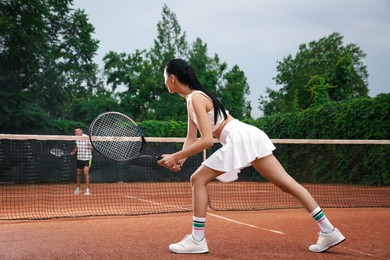 Man and woman playing tennis on court