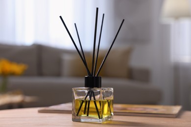 Reed diffuser on wooden table indoors. Cozy atmosphere