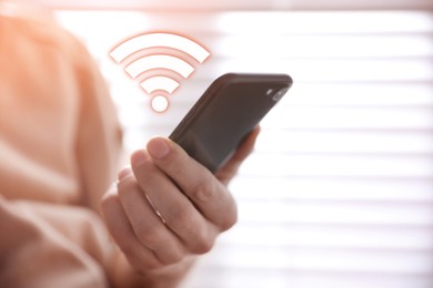Man using smartphone connected to WiFi indoors, closeup