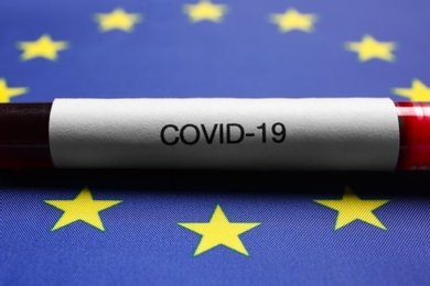 Test tube with blood sample on European Union flag background, closeup. Coronavirus outbreak