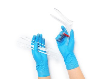 Doctor holding disposable vaginal speculum and gynecological examination kit on white background, top view