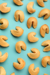 Tasty fortune cookies with predictions on light blue background, flat lay