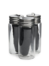 Rolls of natural organic dental floss in jars on white background