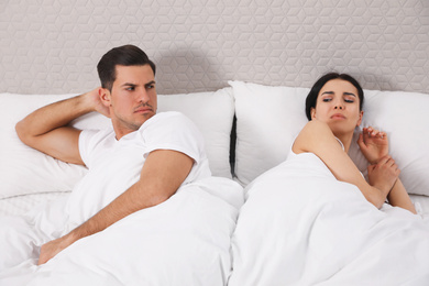 Unhappy couple with relationship problems after quarrel in bed at home
