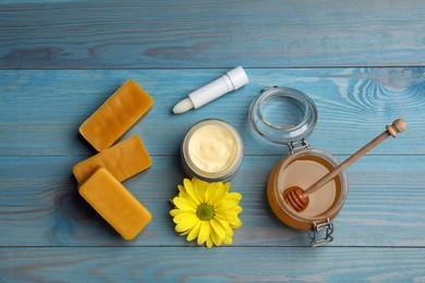 Flat lay composition with beeswax and cosmetic products on blue wooden table