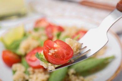 Photo of Fork with delicious quinoa salad, closeup view