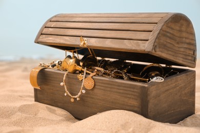 Open wooden treasure chest on sandy beach