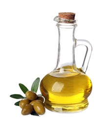 Glass jug of oil, ripe olives and leaves on white background
