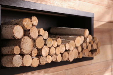 Decorative fireplace with stacked wood indoors. Idea for interior design