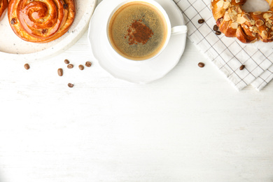 Fresh tasty pastries and coffee on white wooden table, flat lay. Space for text