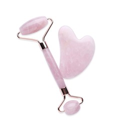 Photo of Rose quartz gua sha tool and facial roller isolated on white, top view
